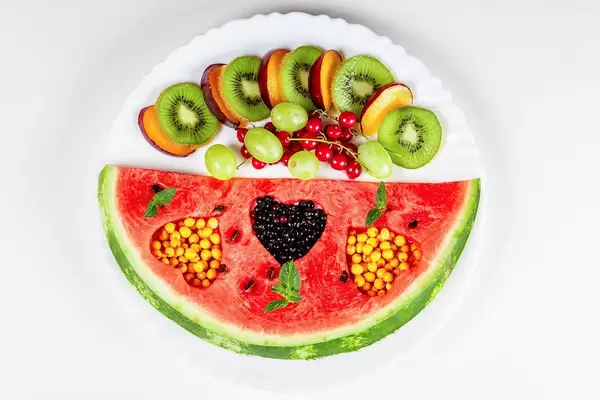 Ripe and sweet summer fruits on a plate, top view
