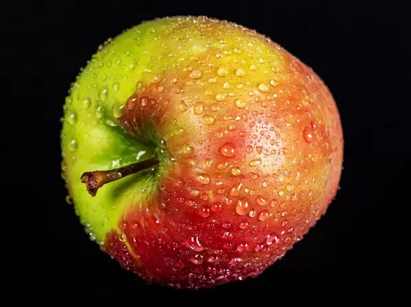 Ripe apple with water drops on a dark background