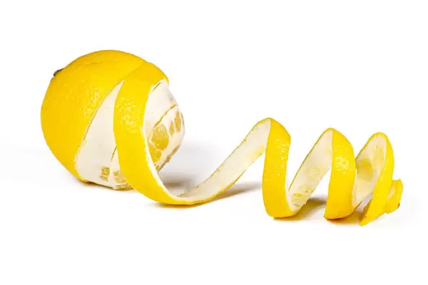 Ripe fresh lemon with peel in the shape of a spiral on a white background