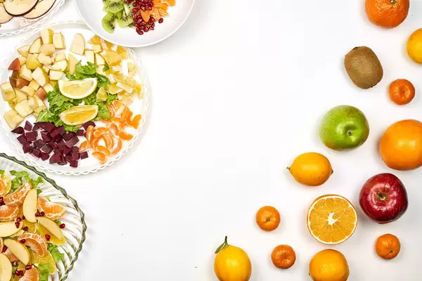 Ripe fruits and fresh salads on white