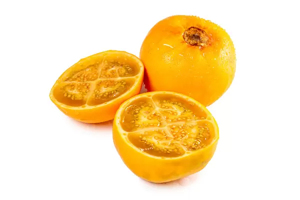 Ripe fruits whole and cut on a white background