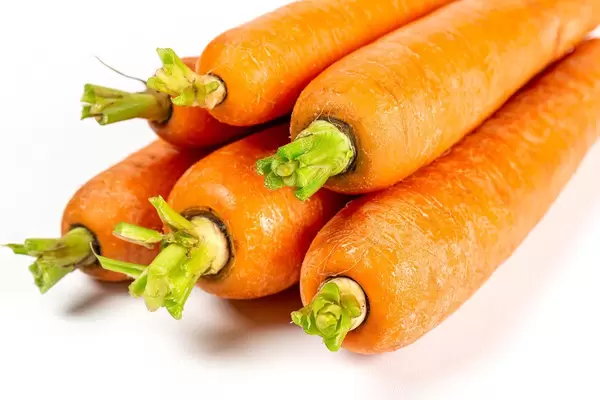 Ripe orange carrots on white, close-up