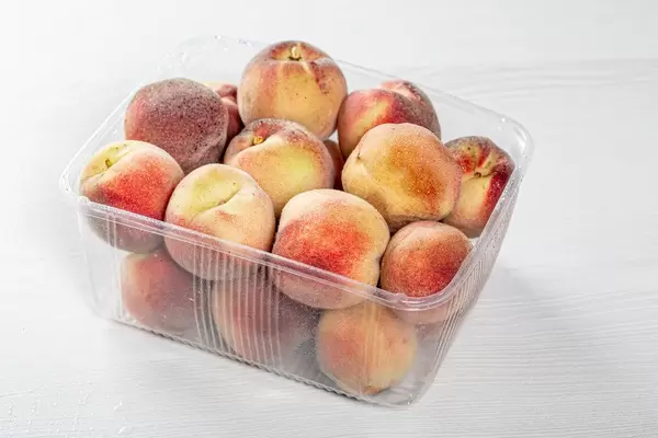 Ripe peaches in a plastic container