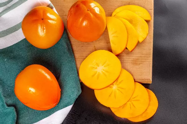 Ripe persimmon slices and whole fruit