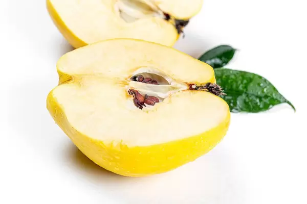 Ripe quince halves with leaves and water drops