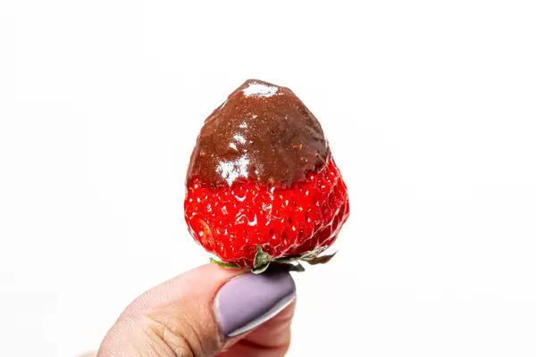 Ripe red strawberries with chocolate in a woman's hand (Flip 2019)