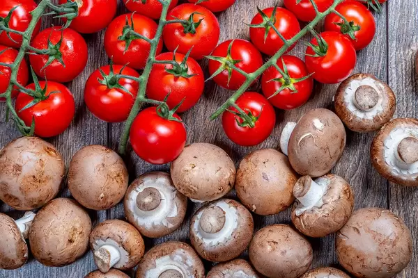 Ripe red tomatoes on branches with brown fresh mushrooms (Flip 2019)