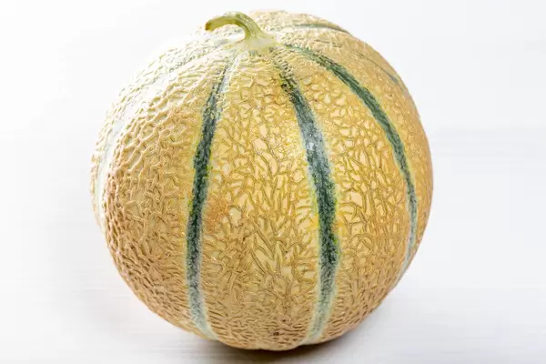 Ripe round melon on white wooden table