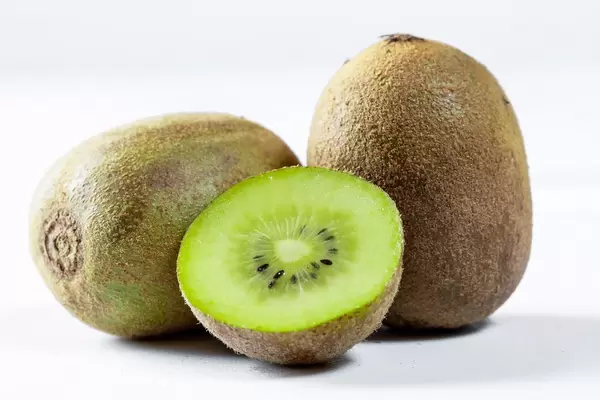 Ripe whole kiwi fruit and half kiwi fruit on white background