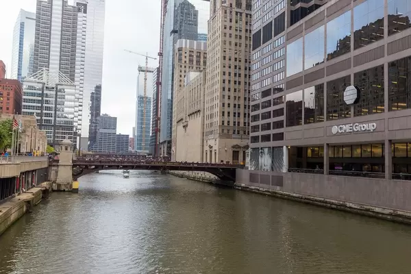 Riverside and building with logo of the CME Group, bridge and skyscrapers in the central business district of Chicago, The Loop