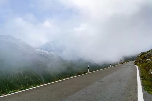 Road high in the Swiss Alps disappearing into the clouds