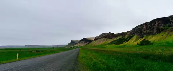 Road in the valley along the mountain range / Straße im Tal entlang der Bergkette