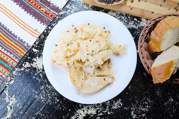 Roast chicken and rice served with homemade bread. Black background (Flip 2019)