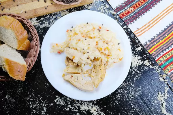 Roast chicken and rice served with homemade bread. Black background