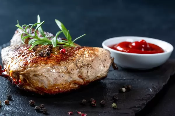 Roast steak with rosemary and spices on black background