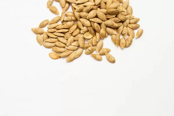 Roasted pumpkin seeds on white background