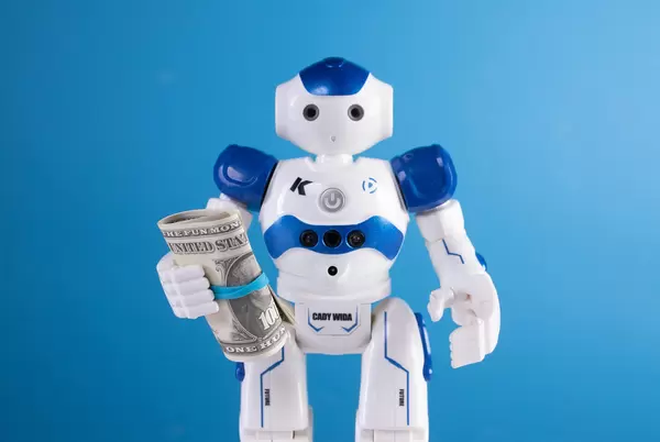 Robot holding dollar banknotes on blue background