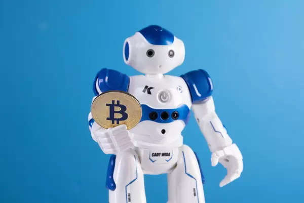 Robot holding golden Bitcoin coin on blue backgorund