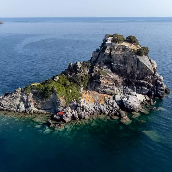 Rock formation surrounded by turquoise waters with chapel and monastery on top: Agios Ioannis, Skopelos