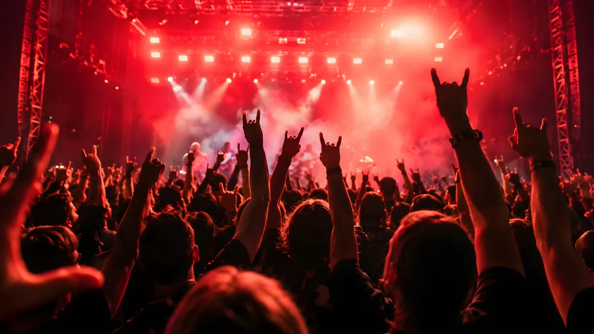 Rockkonzert mit jubelnder Menge und roter Bühnenbeleuchtung