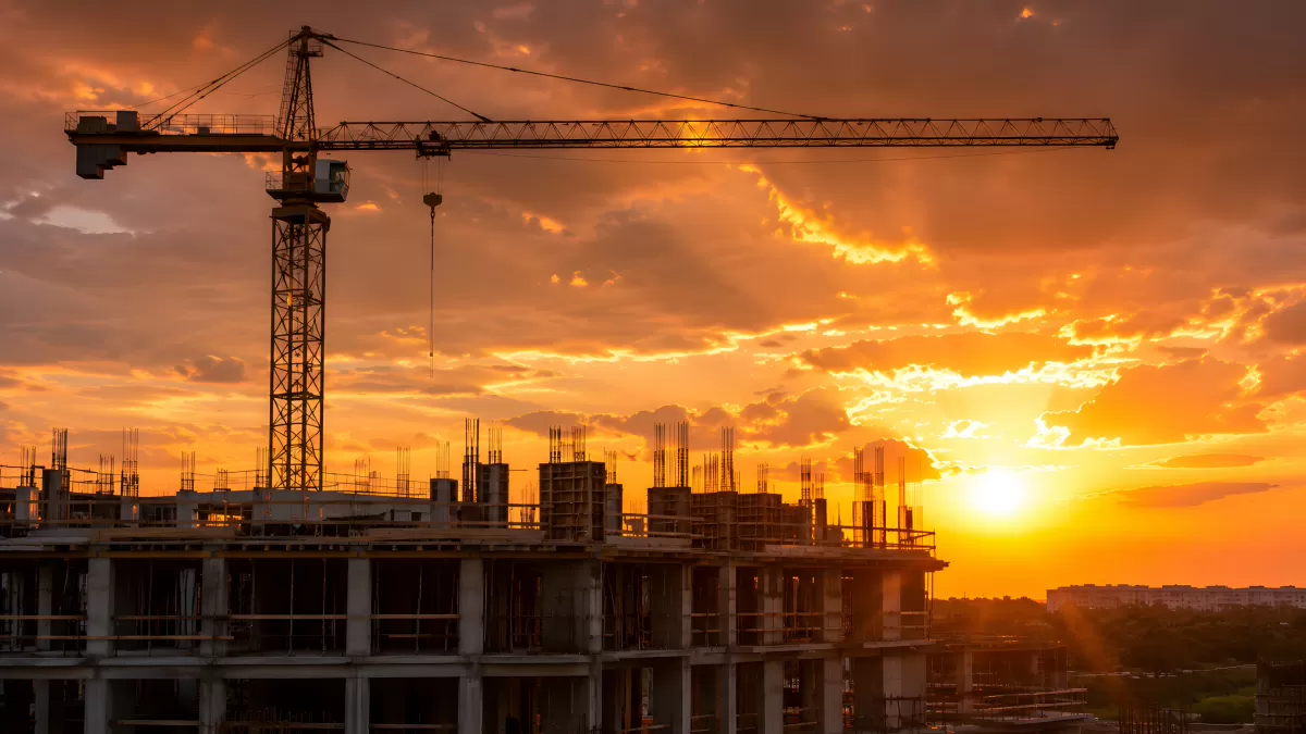 Rohbau mit Turmkran im dramatischen Sonnenuntergang
