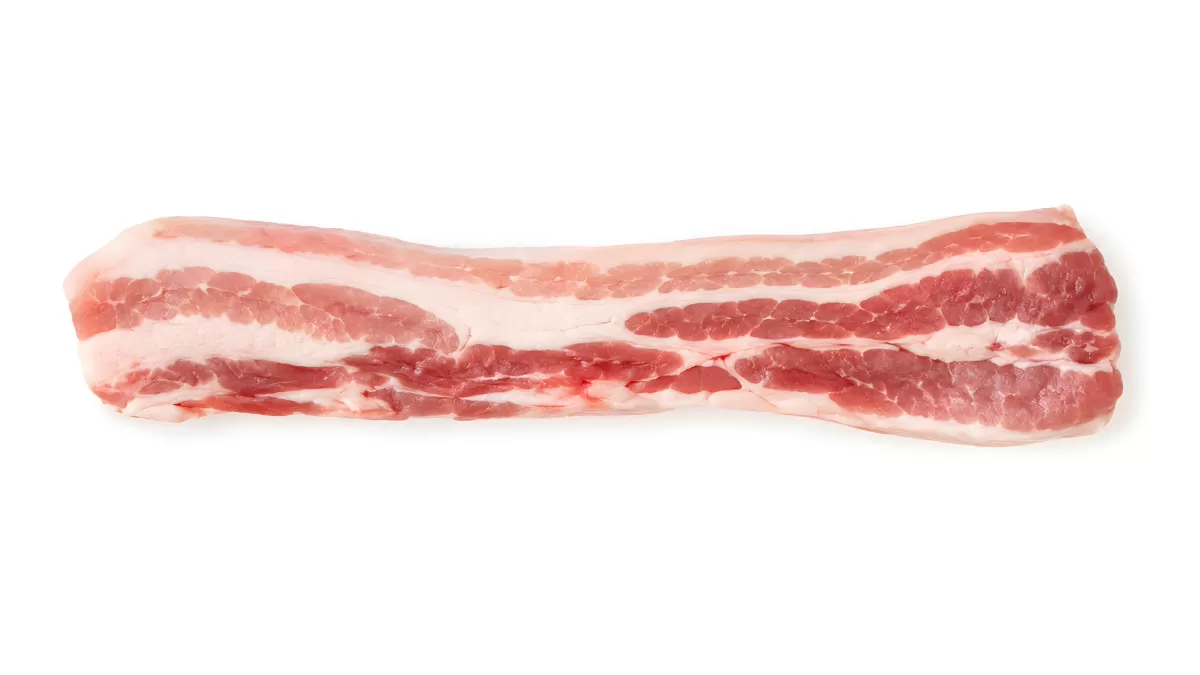 Roher Schweinebauch mit Fettschichten auf weißem Grund