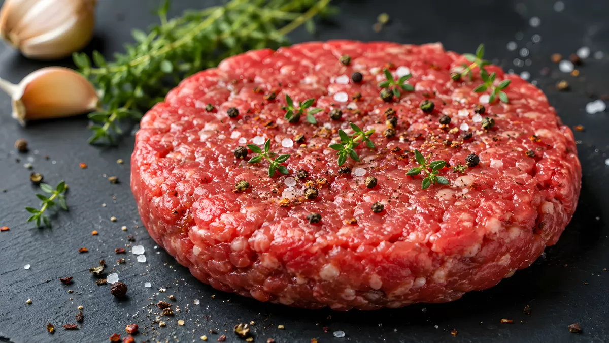 Rohes Burger-Patty mit Salz, Pfeffer und Thymian