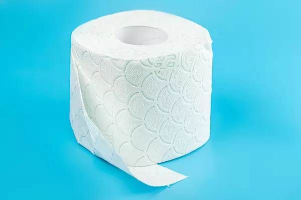 Roll of white toilet paper on blue background