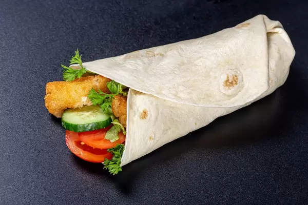 Roll with shrimps, vegetables and sauce on a black background