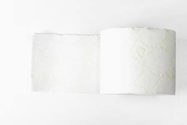 Rolle weiches, weißes Toilettenpapier auf weißem Hintergrund. Aufnahme von oben