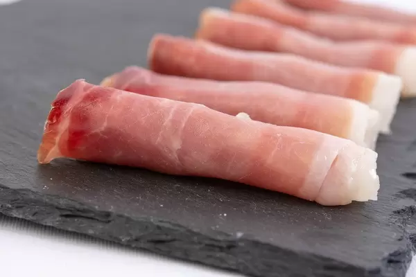 Rolled Pork Ham meat on the black stone tray