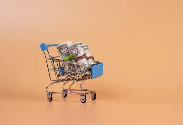 Rolls of dollar banknotes in shopping cart