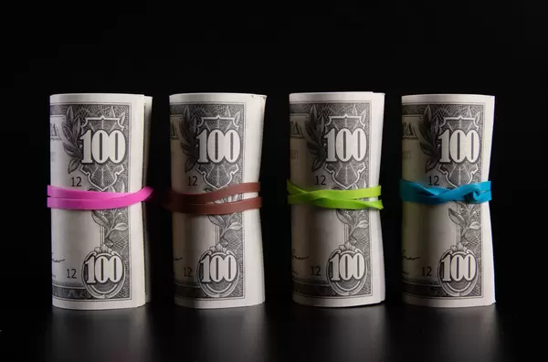 Rolls of dollar banknotes on black background