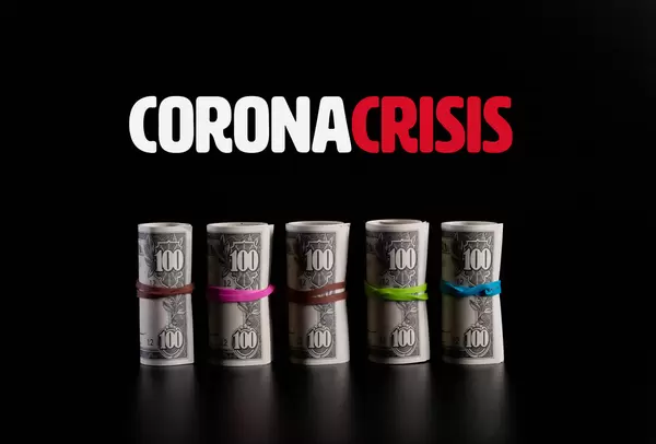 Rolls of dollar banknotes with Coronacrisis text on black background