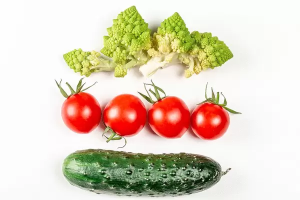 Romanesco, tomatoes and cucumber on a white background, top view (Flip 2020)