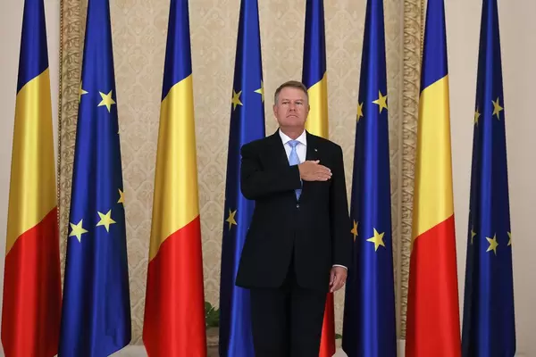 Romanian President Klaus Iohannis, flag of Romania and European Union on background