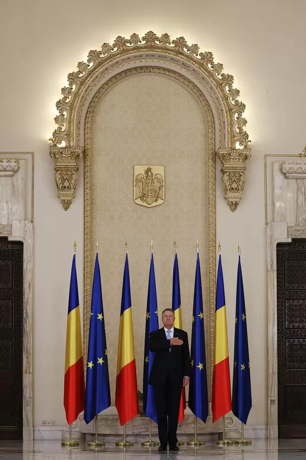 Romanian President Klaus Iohannis stands while listening the national anthem at Cotroceni Palace