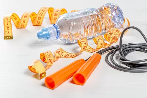 Rope, water bottle and measuring tape on white background. The concept of sports