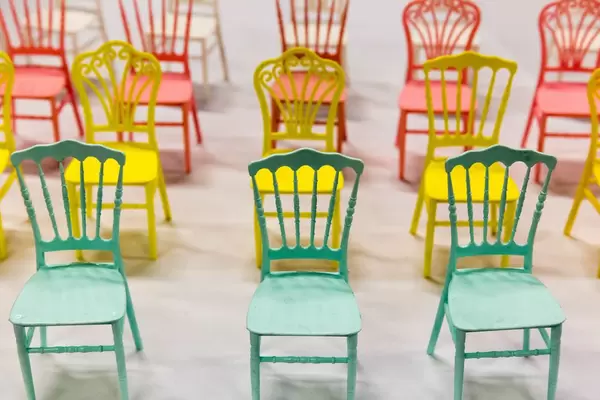 Rosa, gelbe und türkisfarbene winzige Stühle
