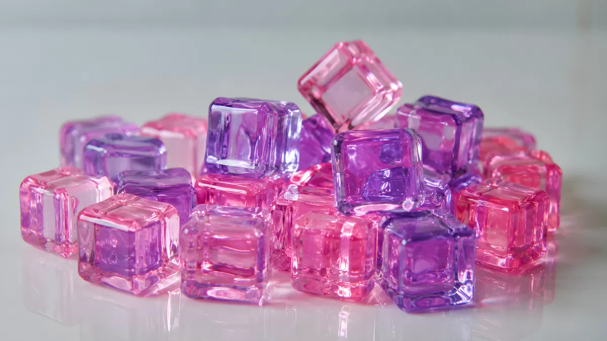 Rosa und lila Eiswürfel aus Kunststoff auf weißem Untergrund