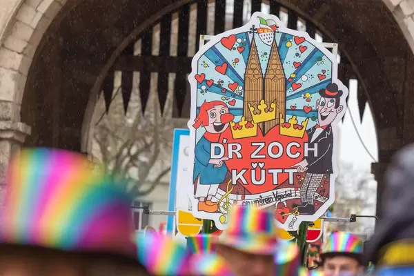 Rosenmontagsumzug in Köln: Schild mit Schrift "D'r Zoch kütt en unsrem Veedel" ("Der Zug kommt in unserem Viertel" in Kölsch) am Severinstor