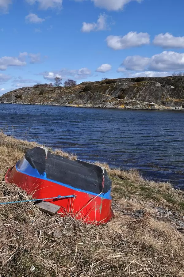 Rot-blauer Ruderboot am Ufer