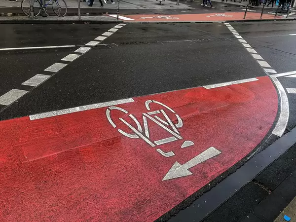 Rot markierter Fahrradweg führt von einer Straßenseite zur anderen