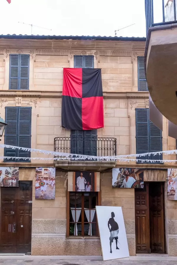 Rot-schwarze Fahne und Fotografik 31m Fotoausstellung. Sommer 2020 in Pollença, Mallorca