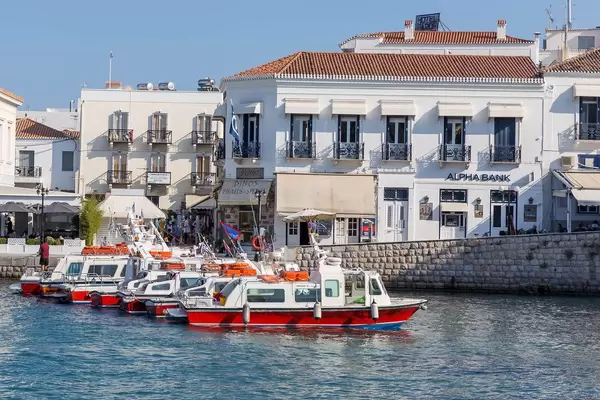 Rot-weiße Wassertaxis als Wassertransportmittel, vor einer griechischen Hafenstadt