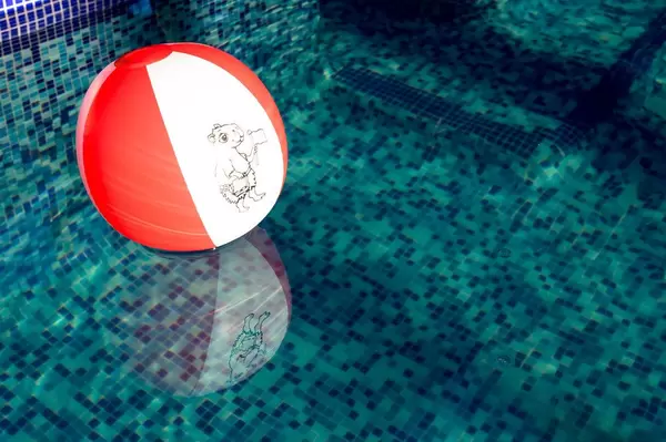 Rot-weißer Strandball im Schwimmbecken
