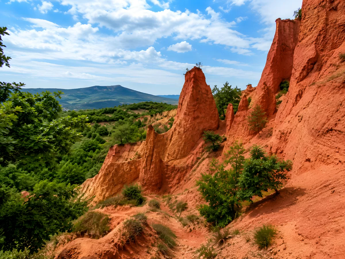 Rote Felsnadeln in einer Schlucht mit Bergpanorama