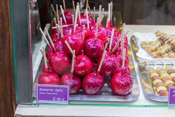 Rote, glasierte Äpfel und weitere weihnachtliche Süßwaren in Verkaufsauslage