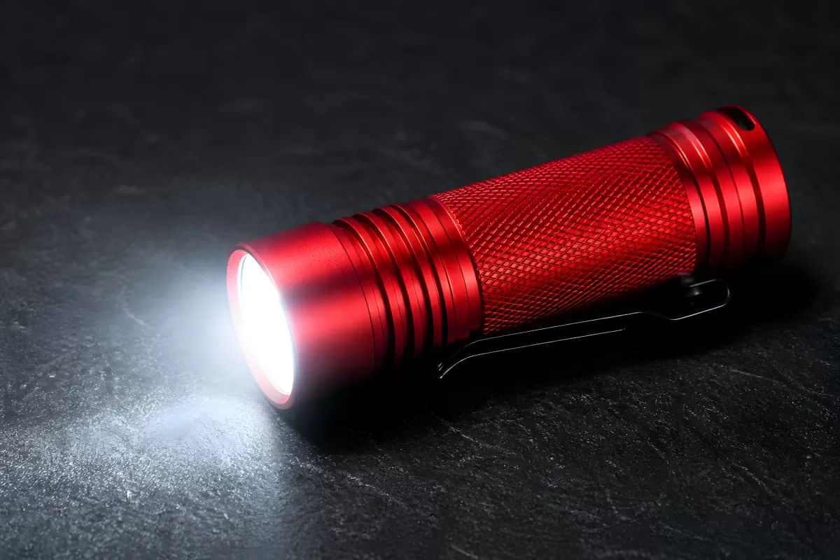 Rote LED-Taschenlampe leuchtet auf dunklem Untergrund