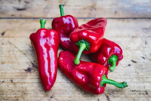 Rote Paprika auf einem rustikalen Holztisch